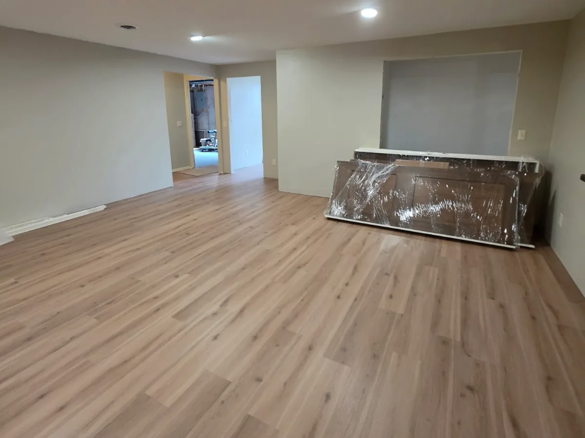 New plank flooring installed in a basement, with doors staged for hanging