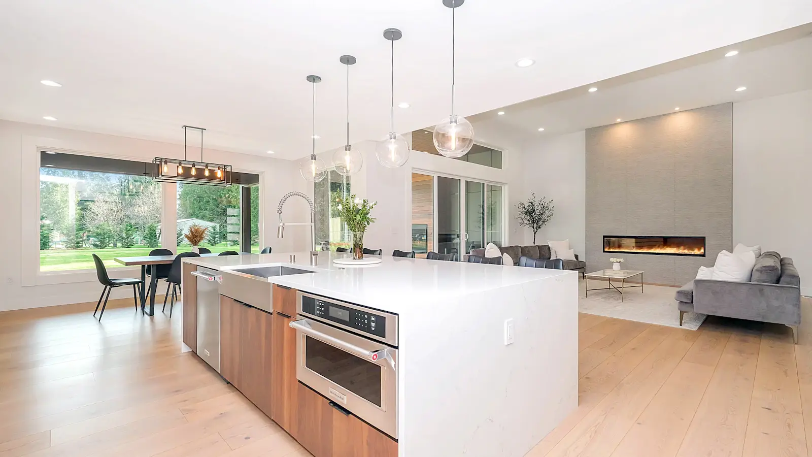 Modern residential kitchen with island, hardwood floors, and open-plan layout
