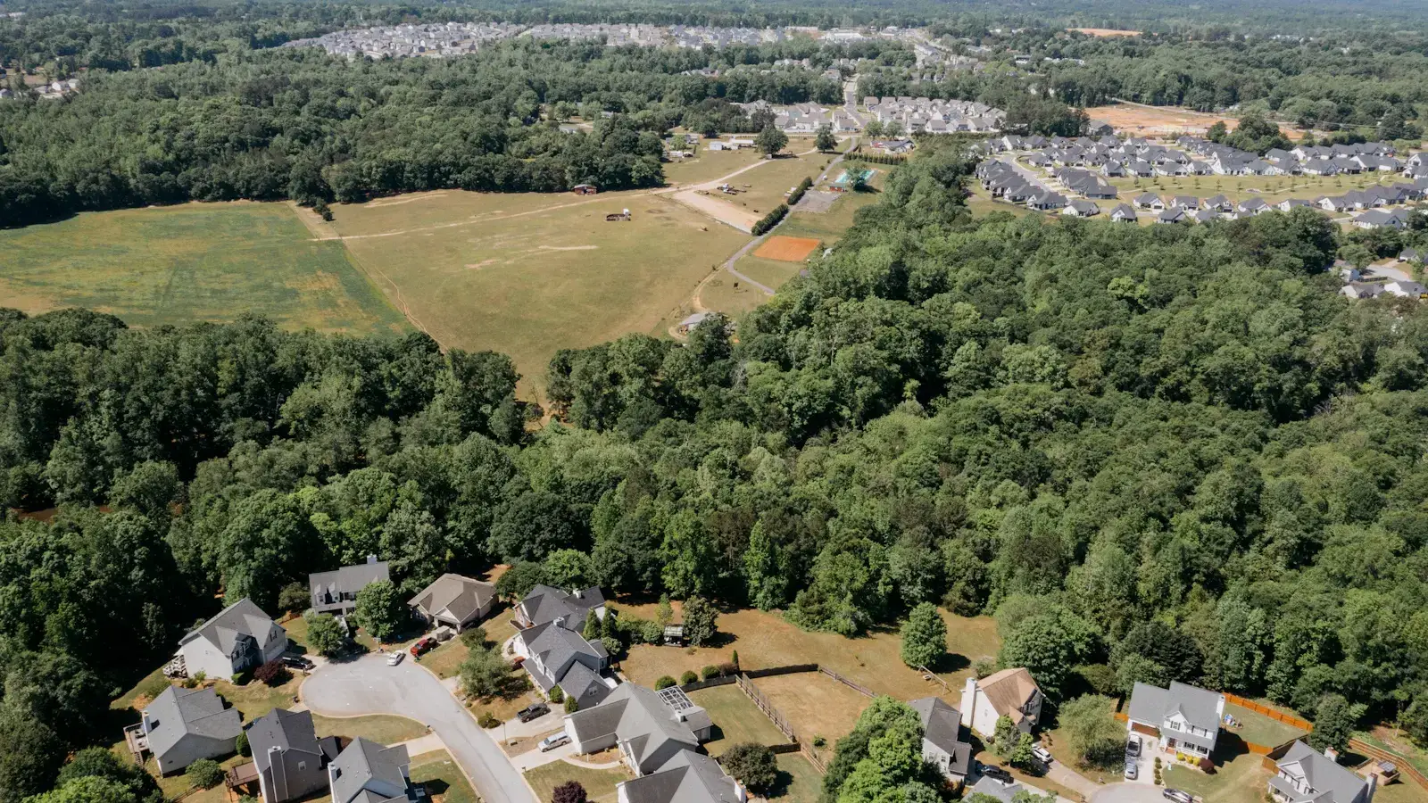 Aerial view of a Midwest residential neighborhood surrounded by trees and farmland